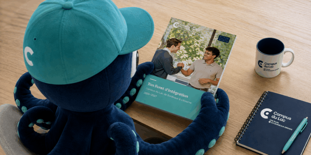 mascotte pourlpy qui tient un livret d'integration pour les 10 conseils pour réussir sa rentrée au campus du lac